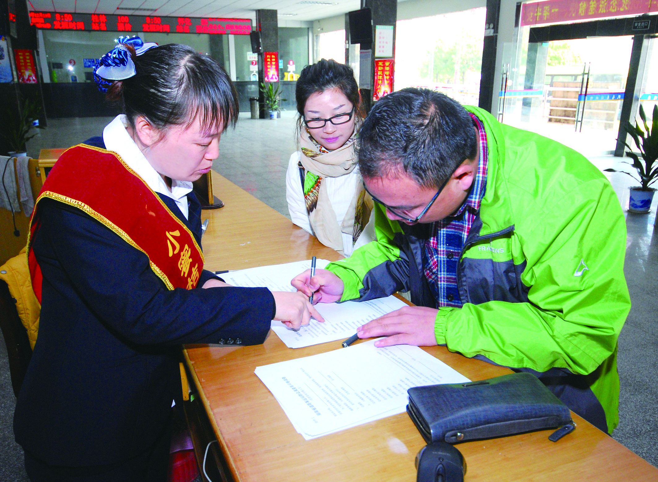 圖為洞口汽車總站站務(wù)人員在熱心為旅客服務(wù)。